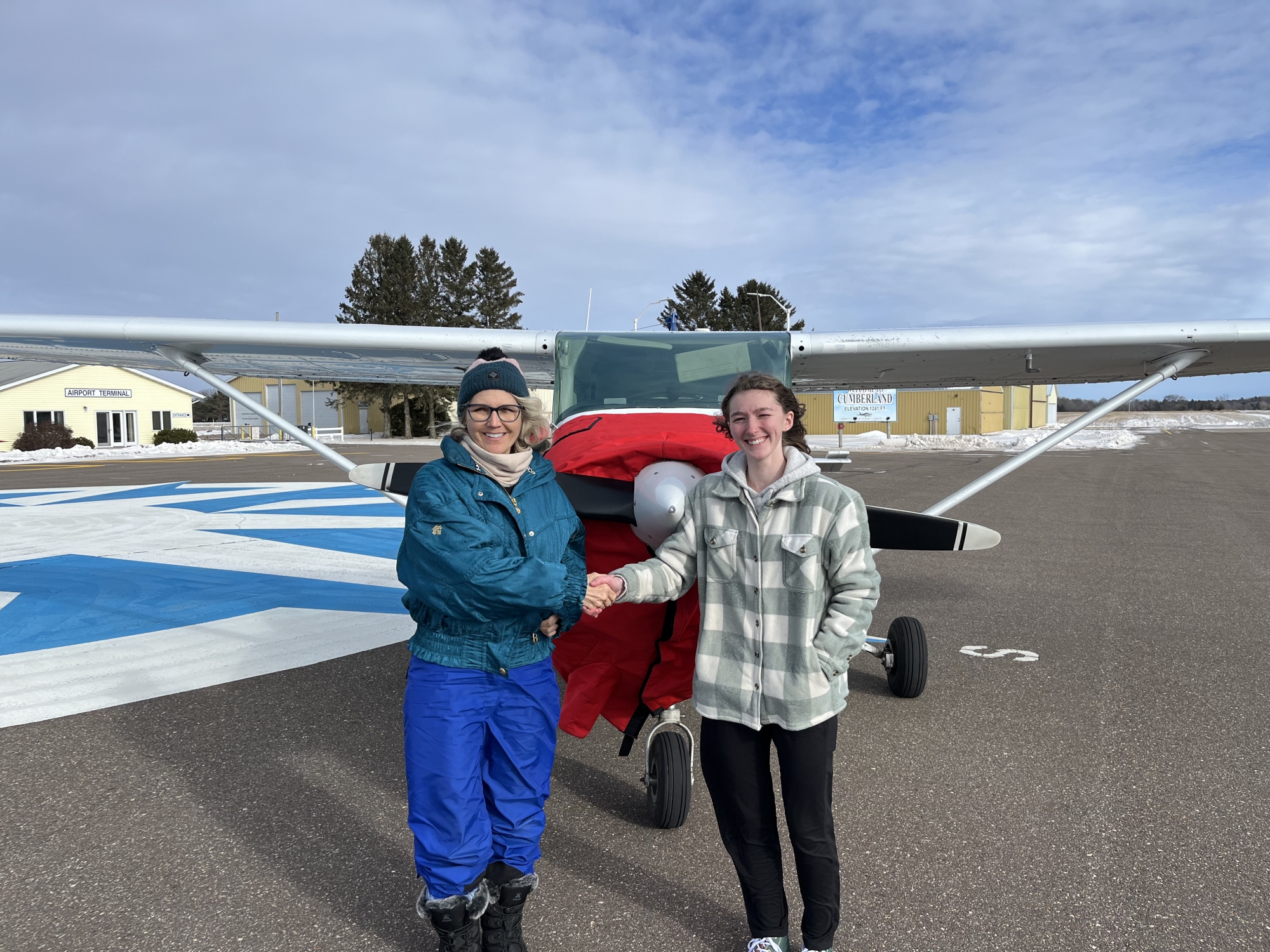 Anna Chase, EAA Chapter 54's Ray Scholar, is congratulated after passing her checkride  January 26, 2025.