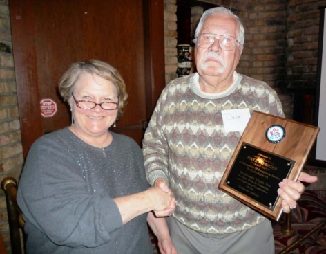 Betty Seitzer gives a plaque to Dave Fiebiger