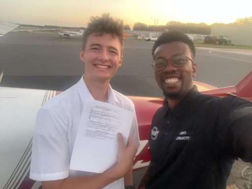 Mathew Lynes poses with his flight instructor after completing his private pilot checkride