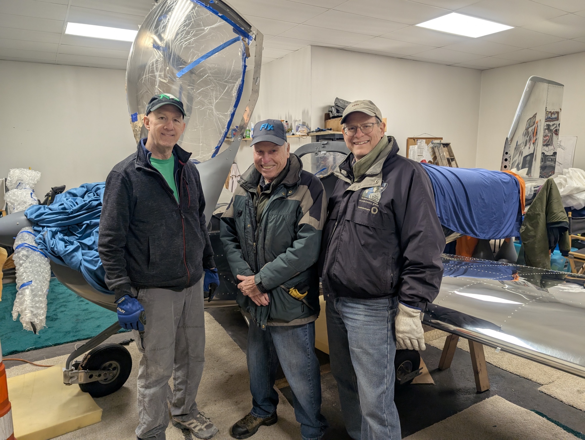 Chapter 54 members Mark Shanahan, Al Kupferschmidt, and Marlon Gunderson did the heavy lifting when attaching Bob Collins' RV-12iS wings. 